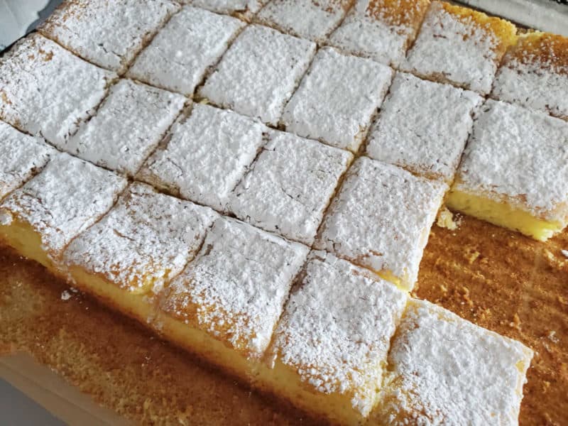 2 Ingredient Lemon Bars cut into squares in a parchment lined baking dish