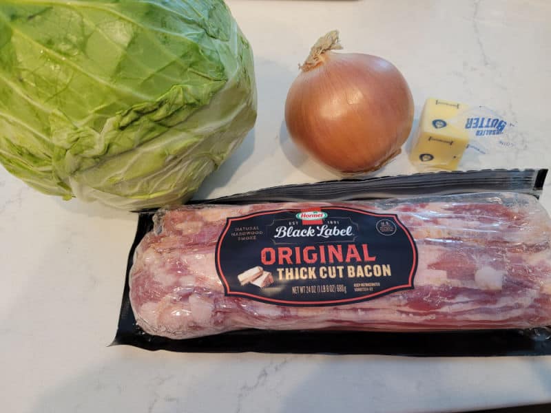 cabbage, onion, butter, and bacon on a white counter