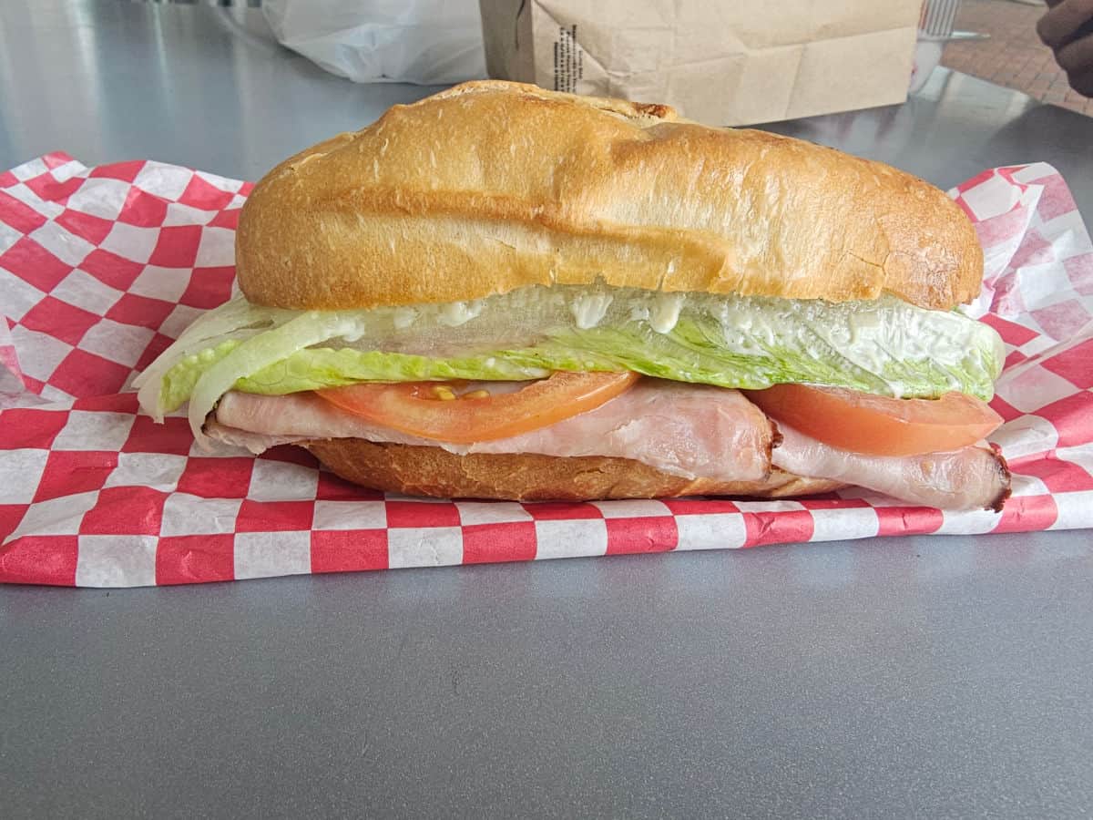 ham sandwich on a red and white checkered paper liner