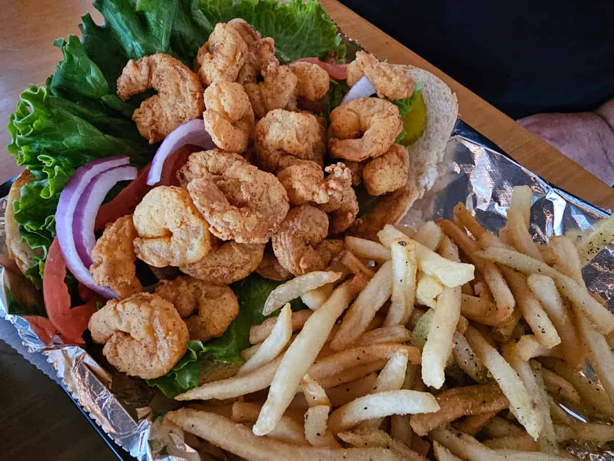 Fried shrimp po'boy in a basket with fries 