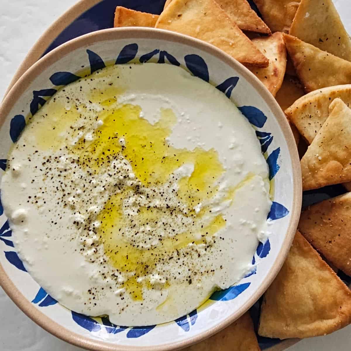 whipped feta dip in a bowl next to pita chips